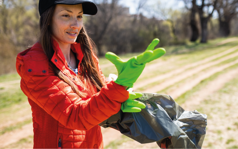 A woman wearing rubber gloves collecting rubbish