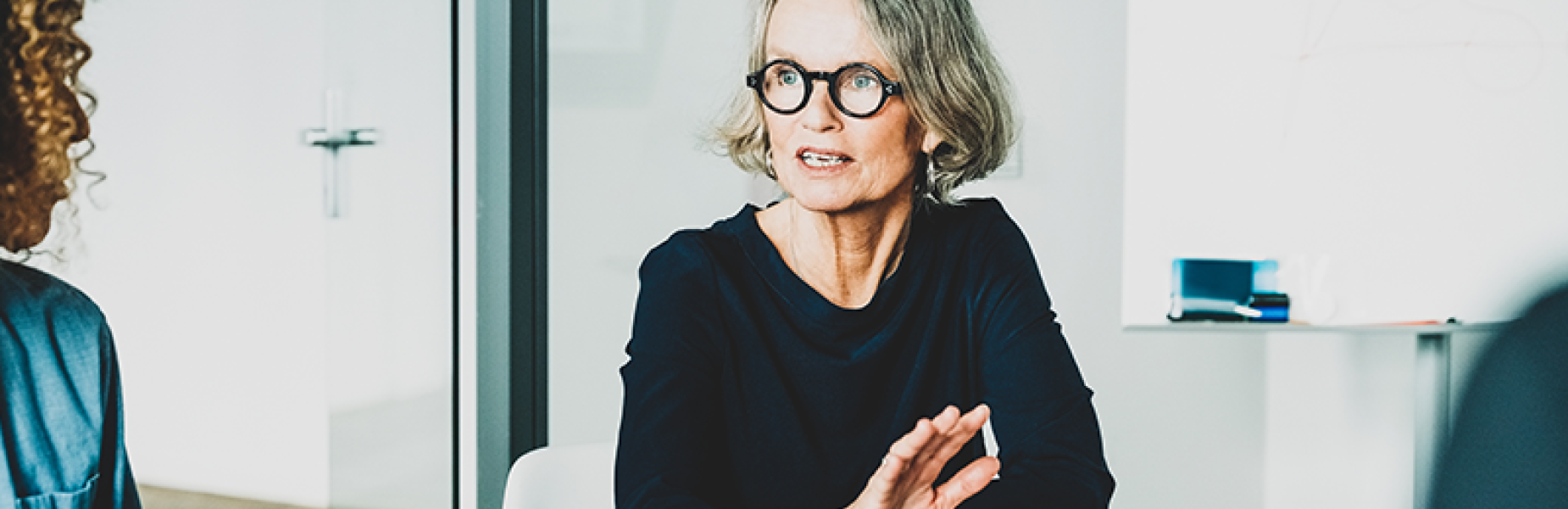 Lady sitting by a desk in a meeting