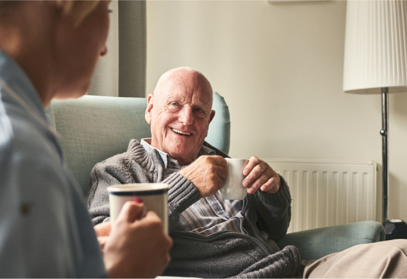 Person smiling with a mug of tea